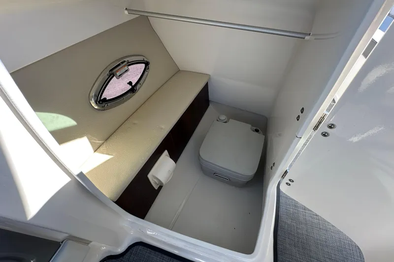 Slide: The Image of Interior of 2015 Chaparral 246 boat with compact toilet and window. - 38
