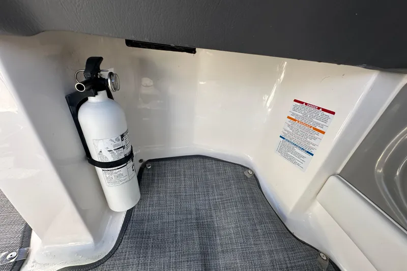 Slide: The Image of Fire extinguisher mounted on 2015 Chaparral 246 boat interior with safety instructions. - 42