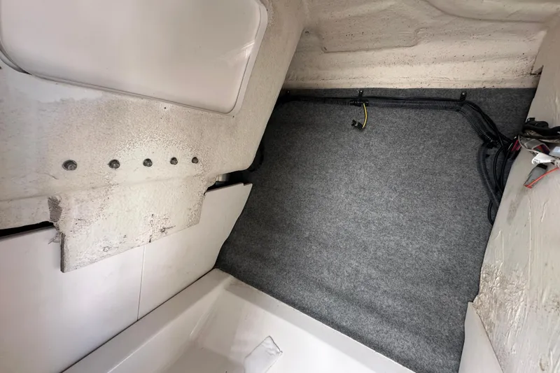 Slide: The Image of Interior view of a 2015 Chaparral 246 boat, showing carpeted flooring and wiring. - 47