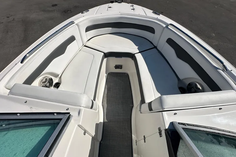 Slide: The Image of 2015 Chaparral 246 boat interior with white cushioned seating and cup holders. - 50
