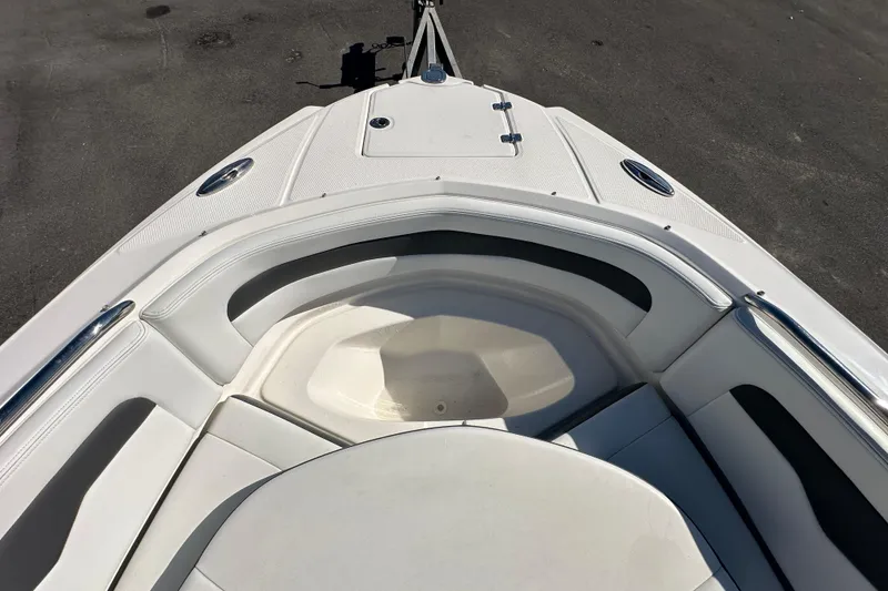 Slide: The Image of Bow seating area of a 2015 Chaparral 246 boat, featuring white upholstery and stainless steel accents. - 56