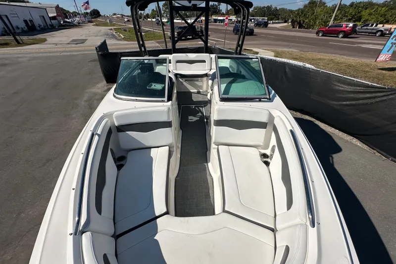 Slide: The Image of 2015 Chaparral 246 boat with spacious seating, parked on a sunny day. - 62