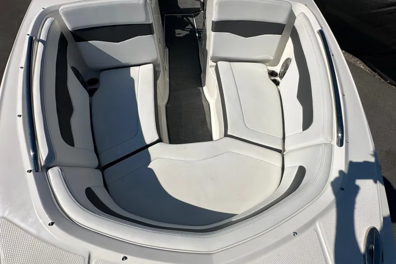 Slide: The Image of 2015 Chaparral 246 boat interior with white cushioned seating and cup holders. - 64