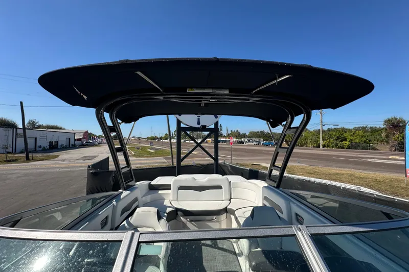 Slide: The Image of 2015 Chaparral 246 boat with canopy, parked on a sunny day near a road. - 65