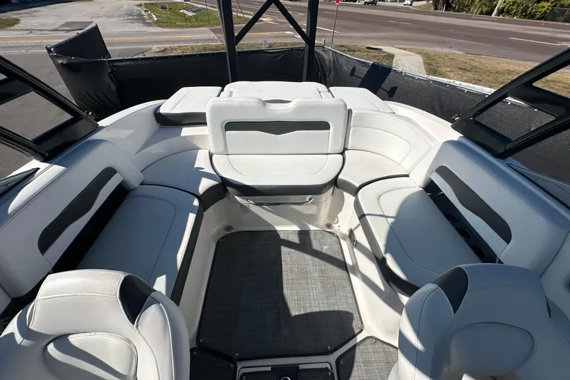 Slide: The Image of 2015 Chaparral 246 boat interior with white seating and open deck layout. - 69