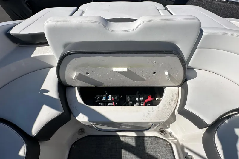 Slide: The Image of 2015 Chaparral 246 boat interior with open storage compartment, revealing battery and wiring. - 75
