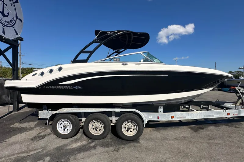 Slide: The Image of 2015 Chaparral 246 boat on trailer, black and white design, sunny day. - 9