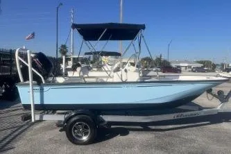 Slide: The Image of 2023 Boston Whaler 170 Montauk boat on trailer, blue hull, parked outdoors. - 5