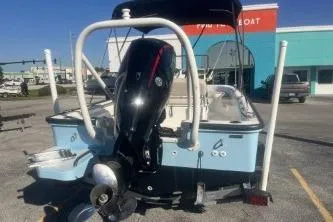 Slide: The Image of 2023 Boston Whaler 170 Montauk boat with outboard motor, parked outdoors. - 6