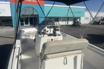 Slide: The Image of 2023 Boston Whaler 170 Montauk boat interior with canopy, parked at a dealership. - 7