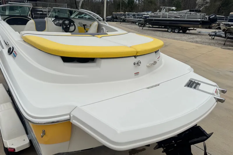 Slide: The Image of 2006 Sea Ray 195 Sport boat with yellow accents, displayed on a trailer. - 2