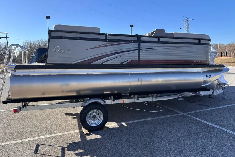 The Image of 2024 Qwest 8518 RLS pontoon boat on trailer in parking lot. - 0