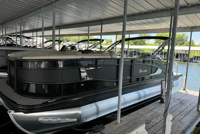 The Image of 2022 Barletta Lusso 23UC pontoon boat docked under a covered marina. - 5