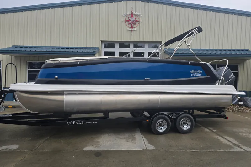 Slide: The Image of 2016 Marker One ML4 pontoon boat on trailer outside marine building. - 2