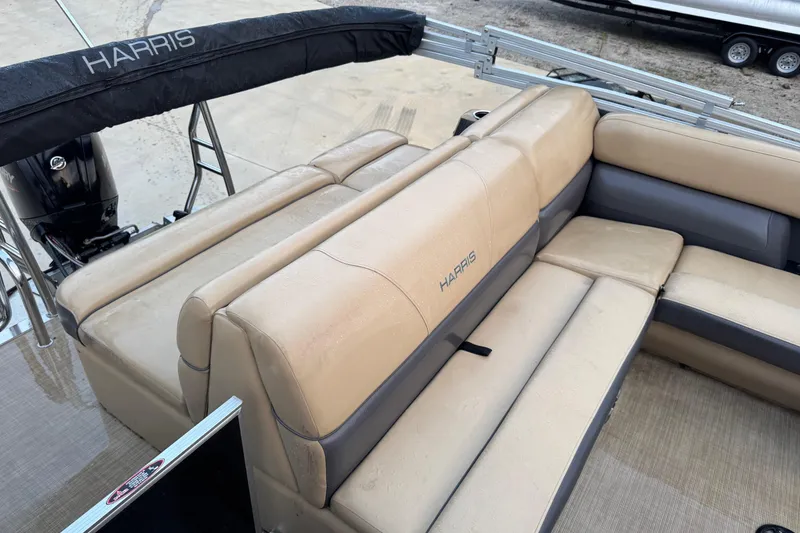 Slide: The Image of 2022 Harris Cruiser 230 boat with beige seating and black canopy. - 4