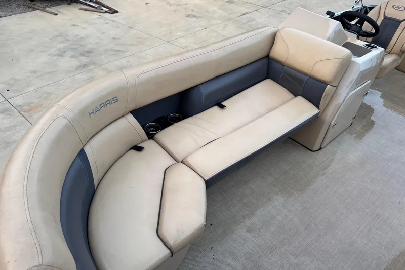 Slide: The Image of 2022 Harris Cruiser 230 boat interior with beige seating and cup holders. - 7