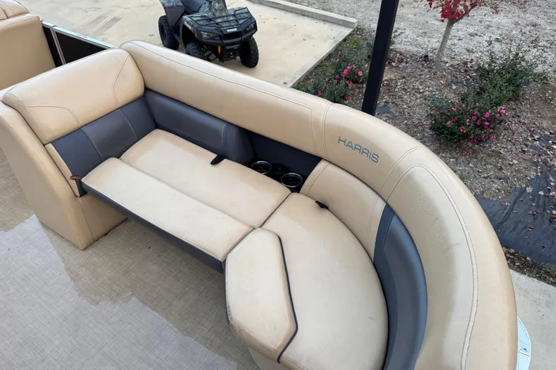 Slide: The Image of 2022 Harris Cruiser 230 boat interior with beige and gray seating. - 8