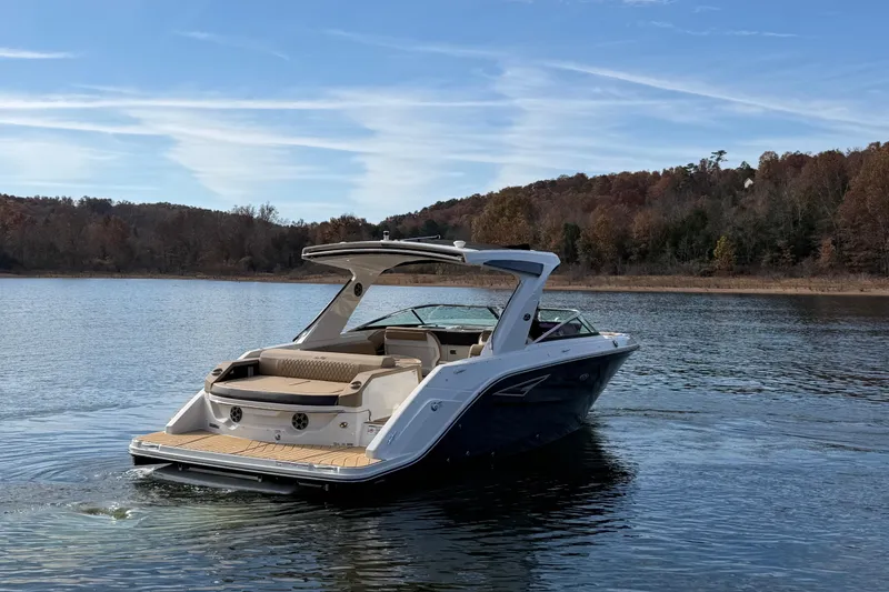 Slide: The Image of 2026 Sea Ray SLX 310 boat cruising on a serene lake with autumn foliage. - 1