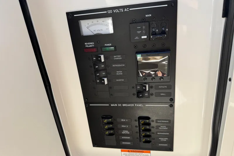 Slide: The Image of Electrical control panel on 2026 Sea Ray SLX 310 boat, featuring AC and DC breakers. - 25