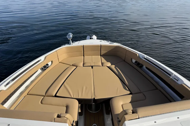Slide: The Image of 2026 Sea Ray SLX 310 boat with luxurious tan seating on calm water. - 27