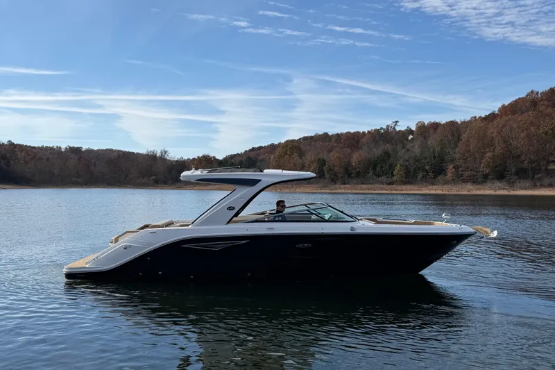 Slide: The Image of 2026 Sea Ray SLX 310 boat on a serene lake with wooded shoreline. - 3