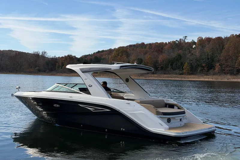 Slide: The Image of 2026 Sea Ray SLX 310 boat cruising on a serene lake with autumn foliage. - 4