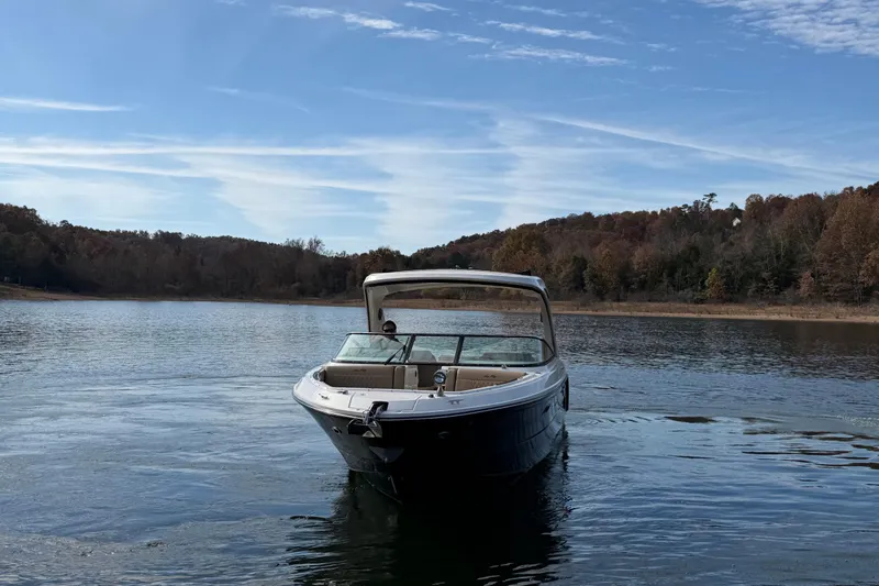 Slide: The Image of 2026 Sea Ray SLX 310 boat on a serene lake with wooded shoreline. - 6