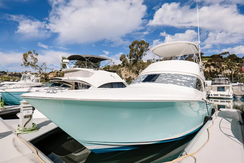 The Image of 2013 Viking 42 Convertible yacht docked at marina under blue sky. - 0