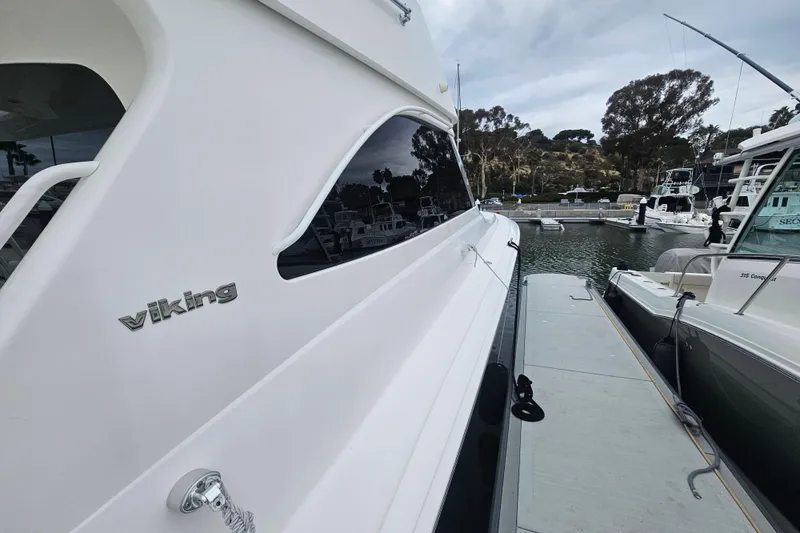 Slide: The Image of 2013 Viking 42 Convertible yacht docked at marina, side view. - 13