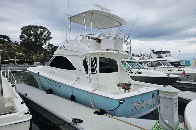 Slide: The Image of 2013 Viking 42 Convertible yacht docked at marina under cloudy sky. - 15