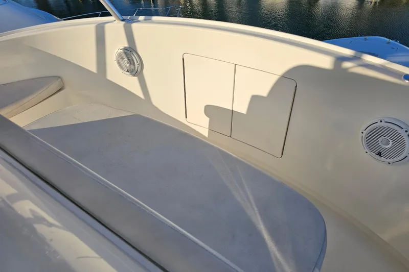 Slide: The Image of 2013 Viking 42 Convertible boat interior with seating and speakers, docked by the water. - 34