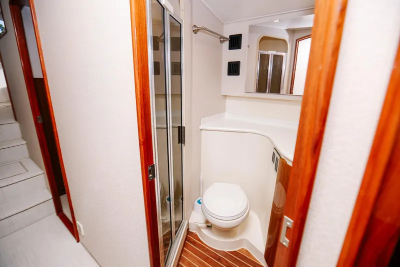 Slide: The Image of 2013 Viking 42 Convertible yacht bathroom with wooden accents and modern fixtures. - 42