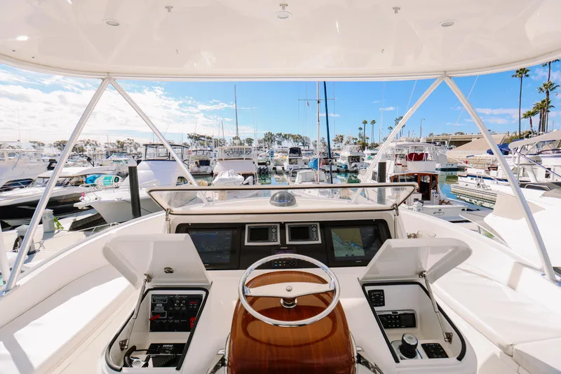 Slide: The Image of Helm view of 2013 Viking 42 Convertible yacht docked in a marina. - 46