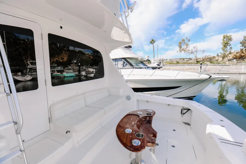 Slide: The Image of 2013 Viking 42 Convertible yacht with sleek design, docked in a serene marina setting. - 48