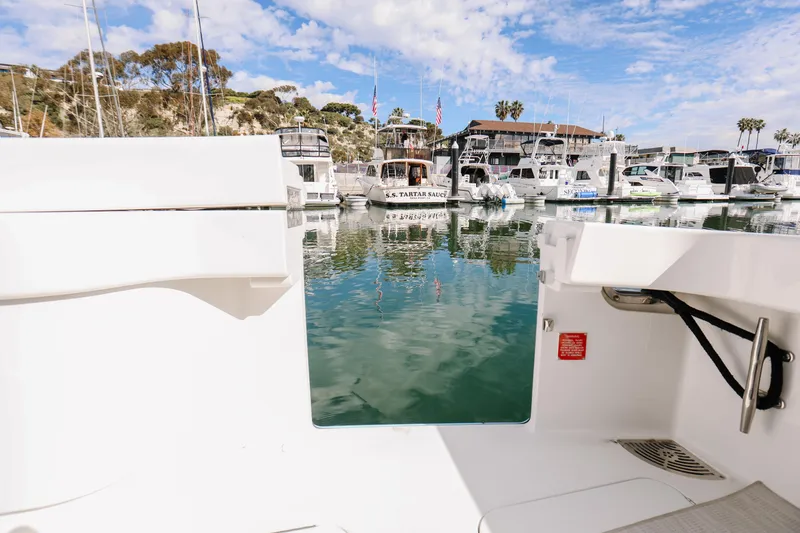 Slide: The Image of 2013 Viking 42 Convertible yacht docked in a scenic marina with clear skies. - 49