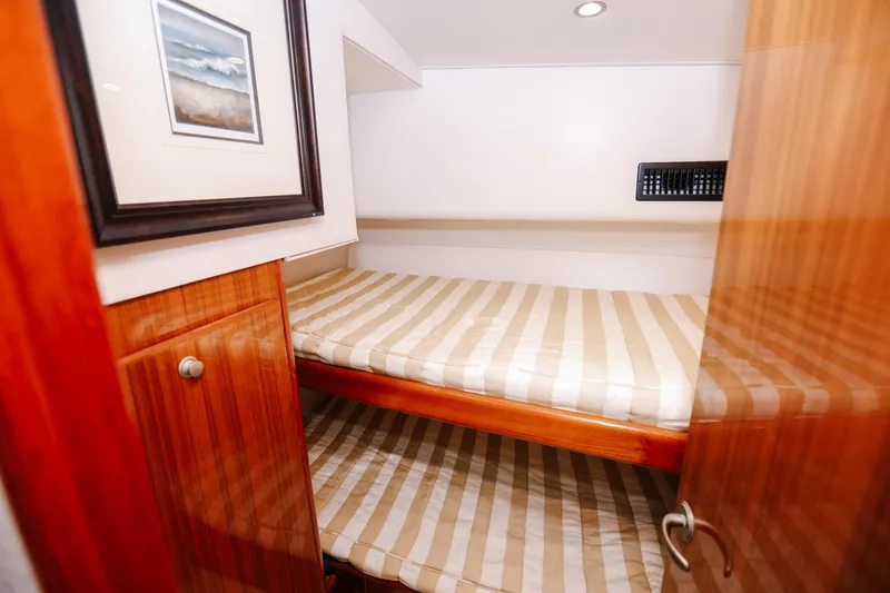 Slide: The Image of 2013 Viking 42 Convertible yacht cabin with bunk beds and wooden cabinetry. - 7
