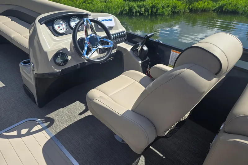 Slide: The Image of 2020 Barletta C24QC boat interior with steering wheel and seating, on calm water. - 10