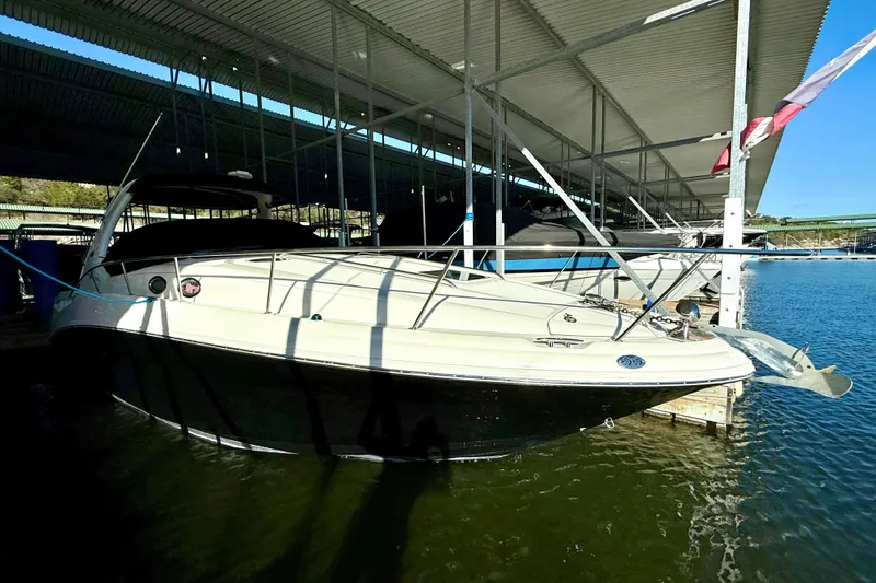 Slide: The Image of 2006 Sea Ray 320 Sundancer docked under a covered marina on a sunny day. - 12