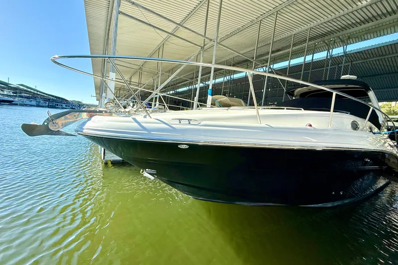 Slide: The Image of 2006 Sea Ray 320 Sundancer docked under a covered marina, side view. - 13