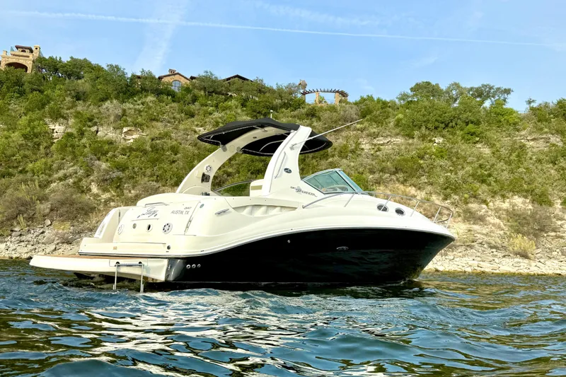 Slide: The Image of 2006 Sea Ray 320 Sundancer boat on a scenic lake with lush green hills. - 2