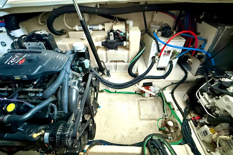 Slide: The Image of Engine compartment of a 2006 Sea Ray 320 Sundancer boat, showcasing mechanical components and wiring. - 28