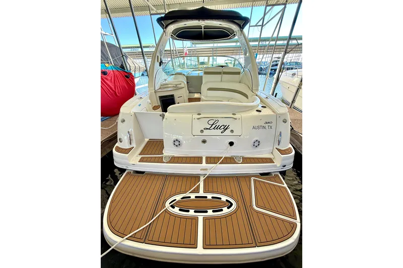 Slide: The Image of 2006 Sea Ray 320 Sundancer boat docked, featuring teak swim platform and seating area. - 35