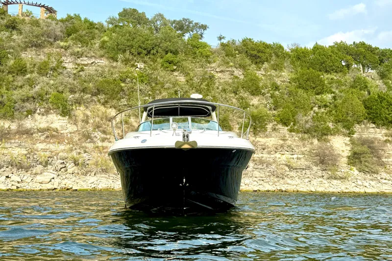 Slide: The Image of 2006 Sea Ray 320 Sundancer boat on water, rocky shoreline background. - 4