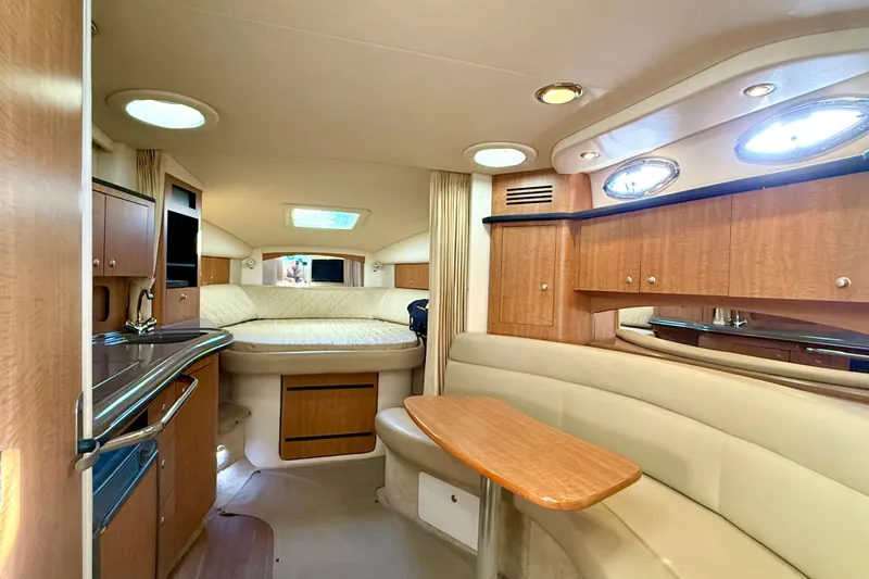 Slide: The Image of 2006 Sea Ray 320 Sundancer cabin interior with wood cabinetry and cozy seating area. - 47