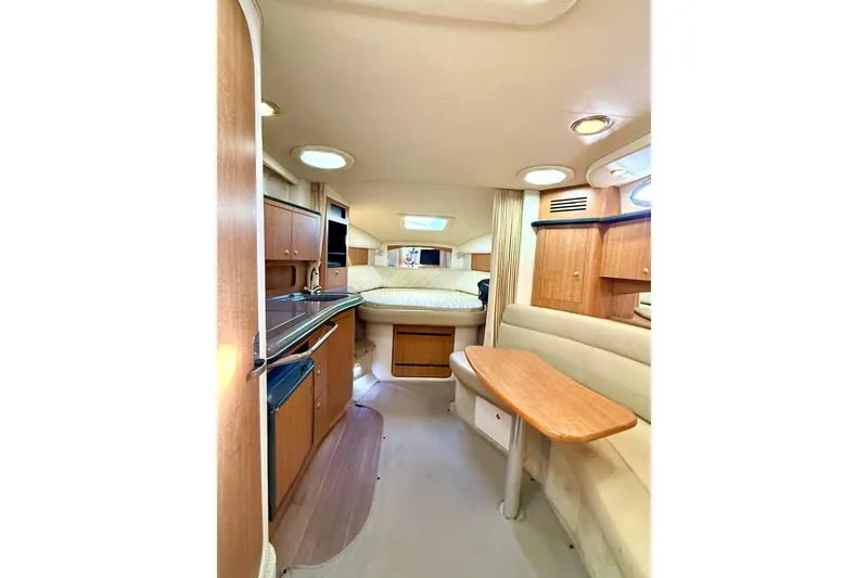 Slide: The Image of Interior of 2006 Sea Ray 320 Sundancer yacht with cozy seating and wooden cabinetry. - 48