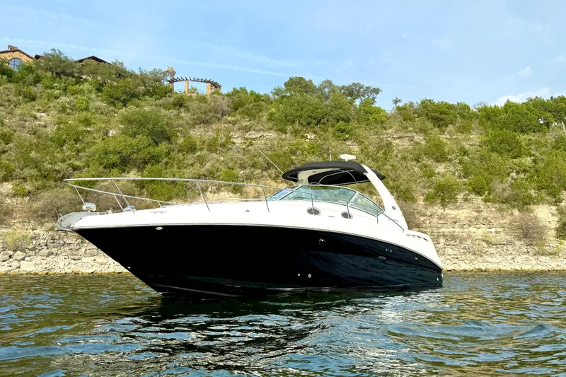 Slide: The Image of 2006 Sea Ray 320 Sundancer yacht on a scenic lake with lush hillside backdrop. - 5