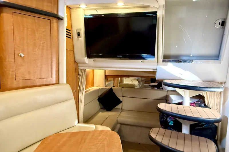 Slide: The Image of Interior of 2006 Sea Ray 320 Sundancer with TV, seating, and wooden cabinetry. - 53