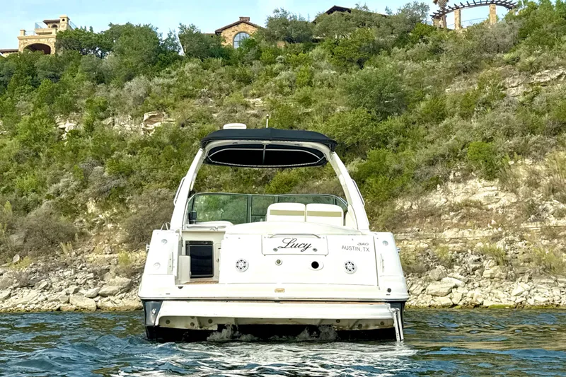 Slide: The Image of 2006 Sea Ray 320 Sundancer boat on water, scenic hillside background. - 8
