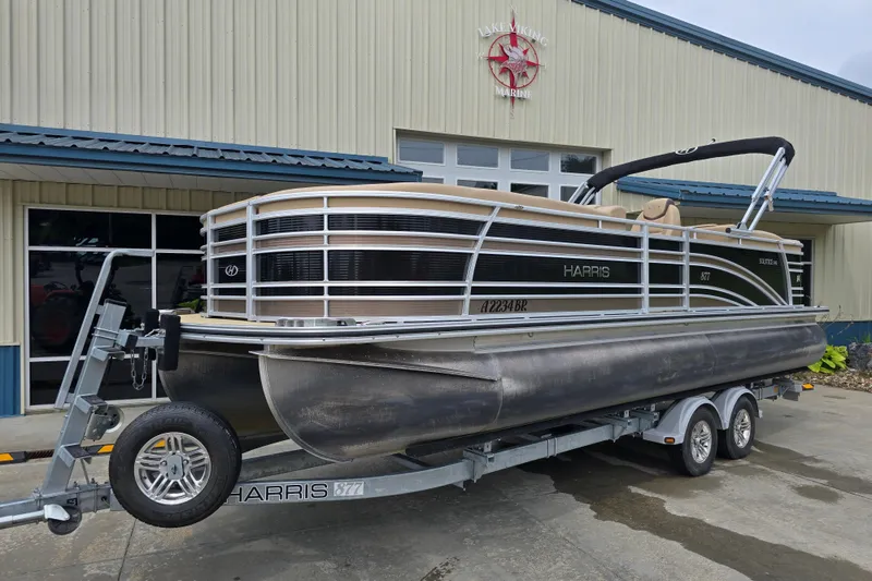 Slide: The Image of 2017 Harris Solstice 240 pontoon boat on trailer outside marine building. - 0