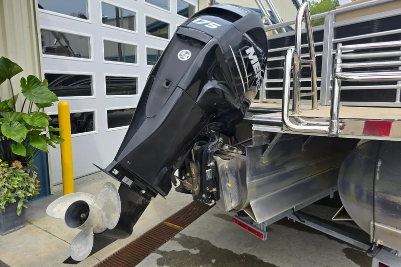 Slide: The Image of 2017 Harris Solstice 240 boat with Mercury outboard motor, docked near a garage. - 12